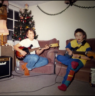 Tim Green (right) playing guitar as a child.