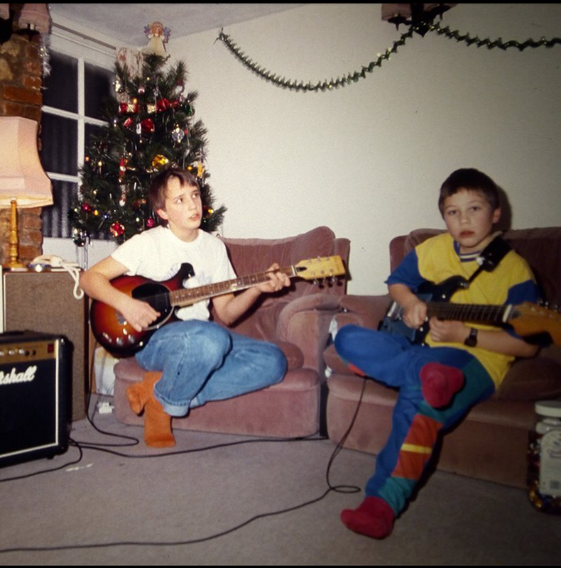 Tim Green (right) playing the guitar as a child.